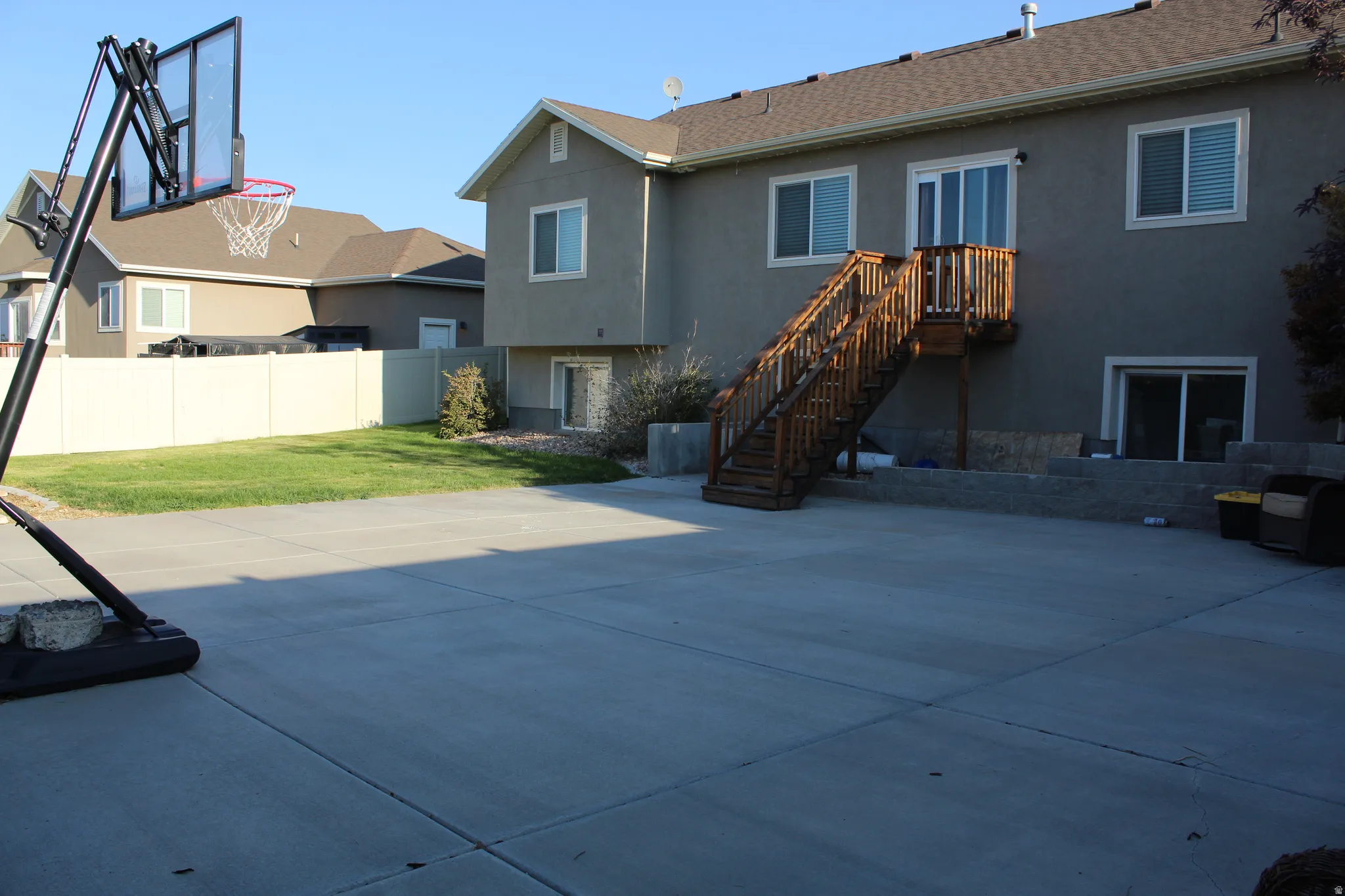 Expansive concrete patio with a wooden exterior staircase
