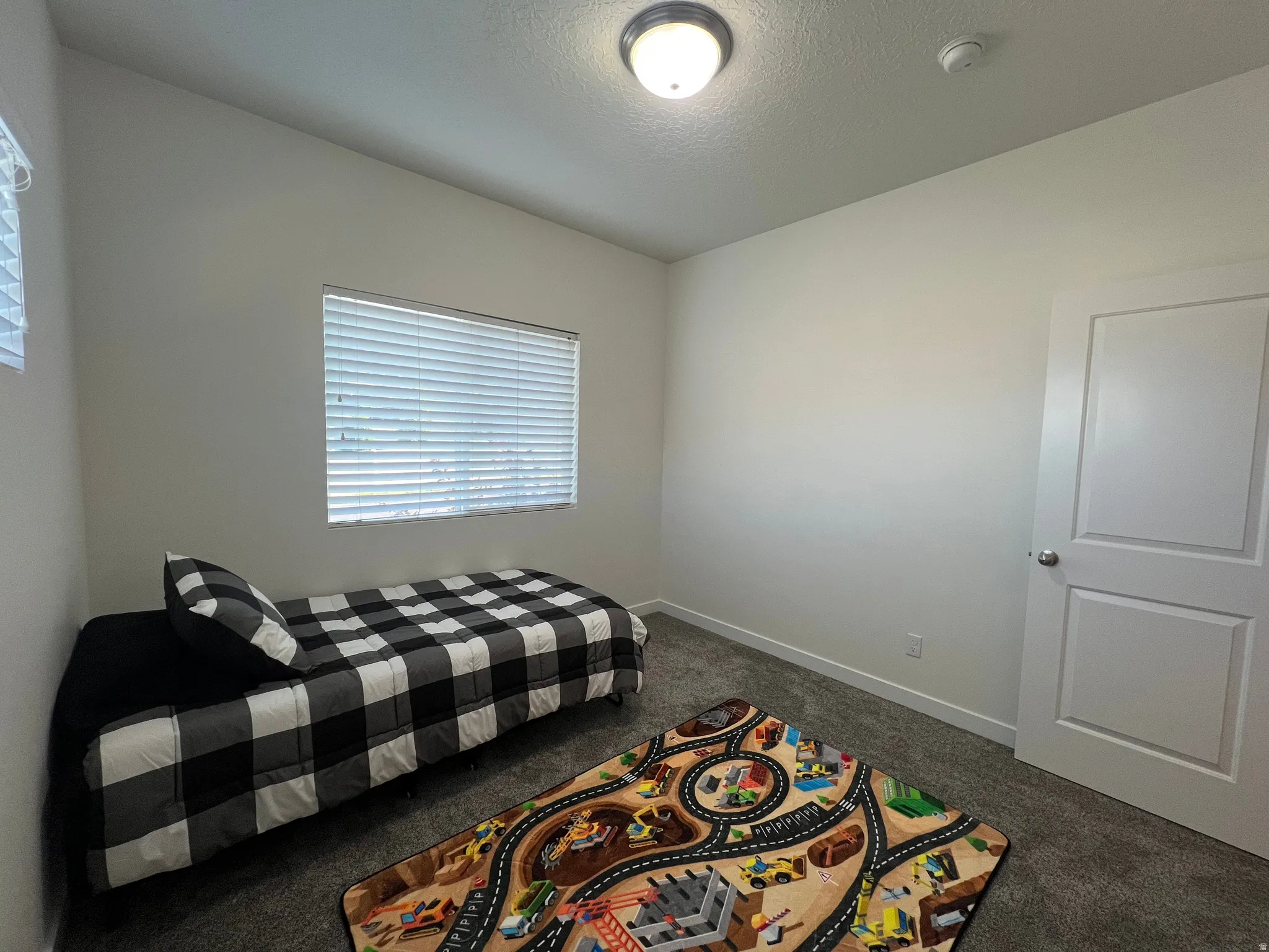 Soft gray walls, window with blinds, recessed lighting, and a white interior door