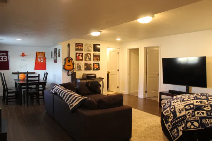 Brightly lit room featuring wood-finish flooring, white walls, and multiple panel doors