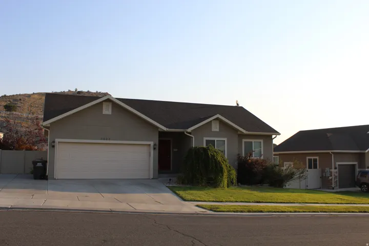 Light gray stucco exterior with a dark shingle roof