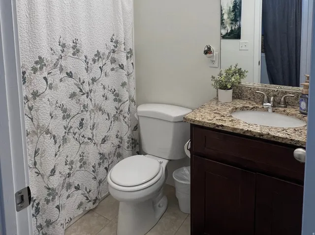 Vanity with granite countertop, integrated sink, and dark wood-finish cabinetry