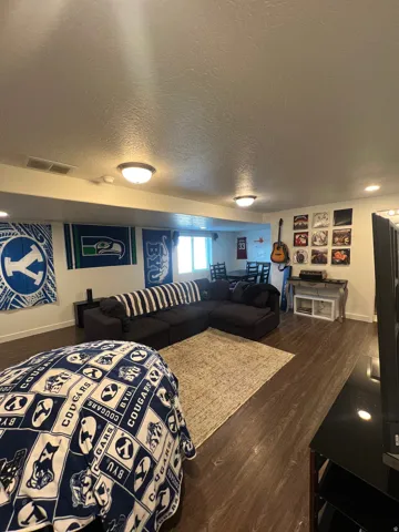 Recessed lighting, wood-finish flooring, and natural light from a window