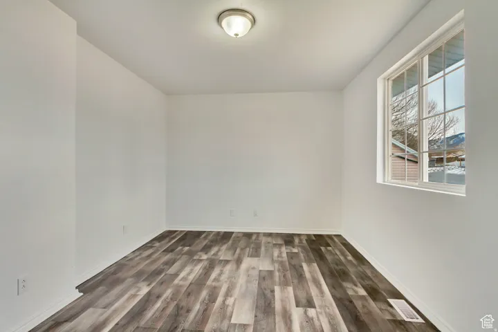 Bright room with wood-finish flooring, white walls, and a multi-pane window