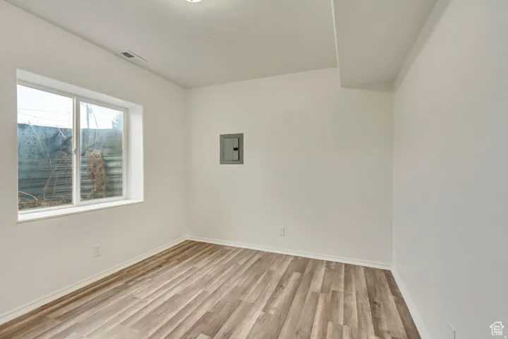 Room featuring wood-finish flooring, white baseboards, and a recessed ceiling light