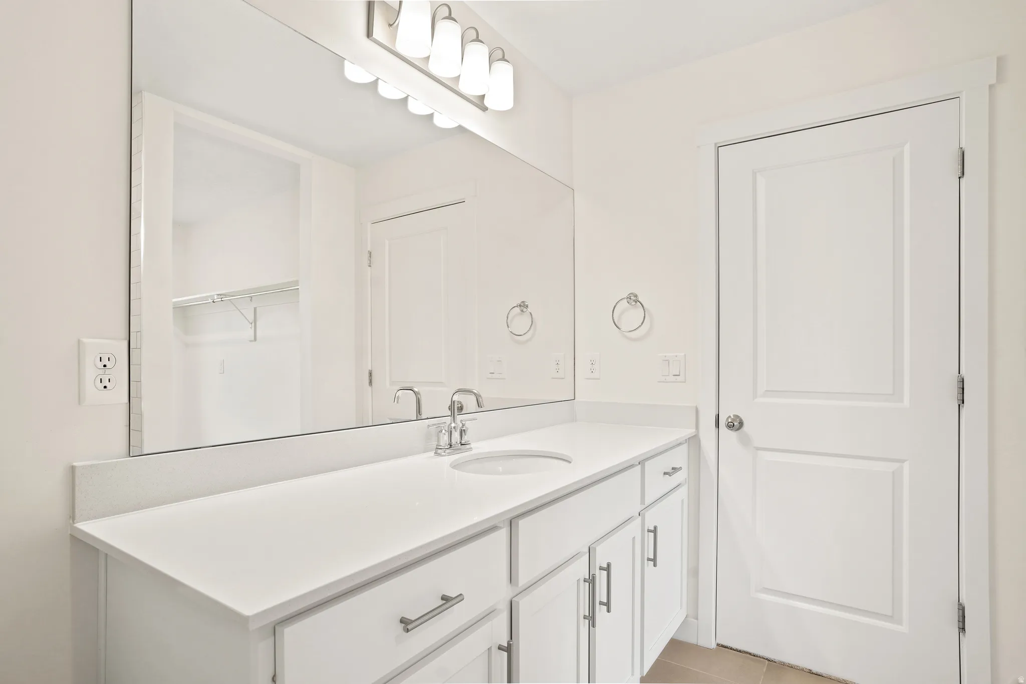 White vanity featuring an integrated sink, polished chrome faucet, and ample under-counter storage