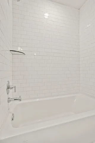 White subway tile surround with chrome fixtures and a built-in tub