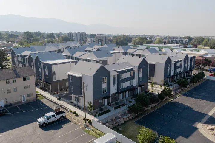 Modern multi-unit residential complex featuring contemporary architectural design with steeply pitched rooflines, dark exterior cladding, and clean geometric forms
