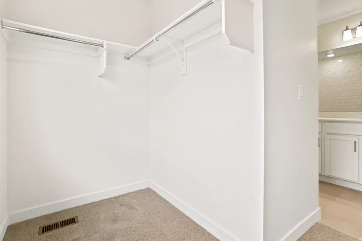 Walk-in closet with carpet flooring and integrated shelving