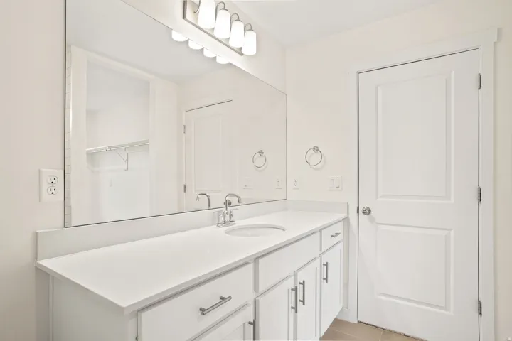 White vanity featuring an integrated sink, polished chrome faucet, and ample under-counter storage