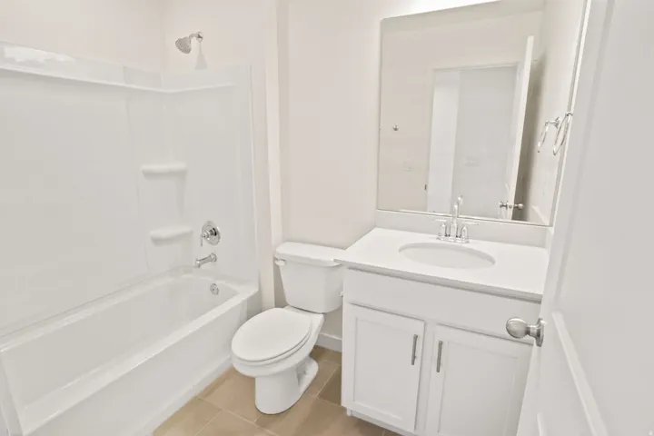 Bathroom featuring a white vanity with an integrated sink, polished chrome faucet, and coordinating hardware