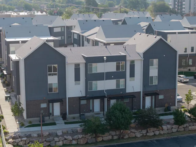 Modern townhome exteriors featuring multi-toned siding, gabled rooflines, and a brick lower facade
