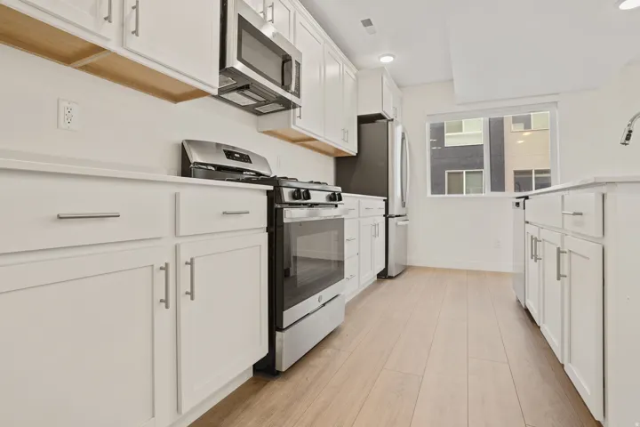 Kitchen featuring white cabinetry, light wood-finish flooring, stainless steel appliances, white countertops, and recessed lighting