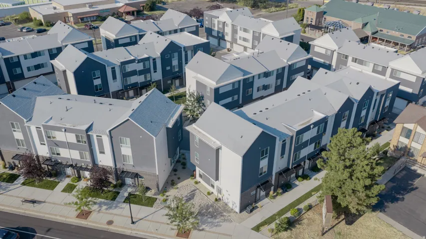 Modern residential development featuring multiple three-story structures with contrasting gray and white exteriors