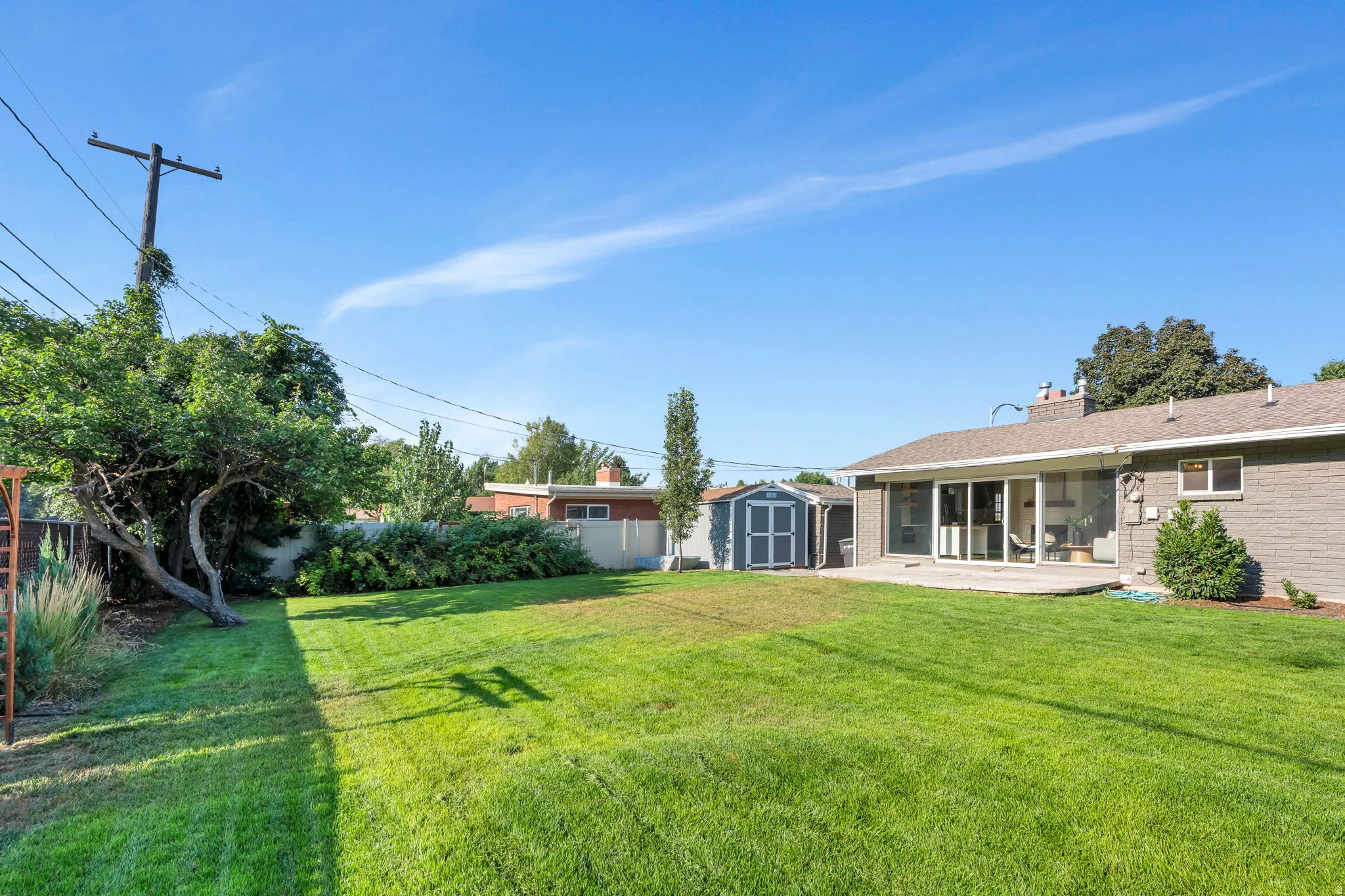 Expansive green lawn with mature perimeter landscaping
