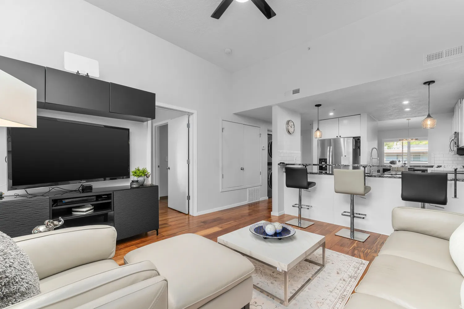 Open-concept living area with wood-finish flooring extending into the kitchen