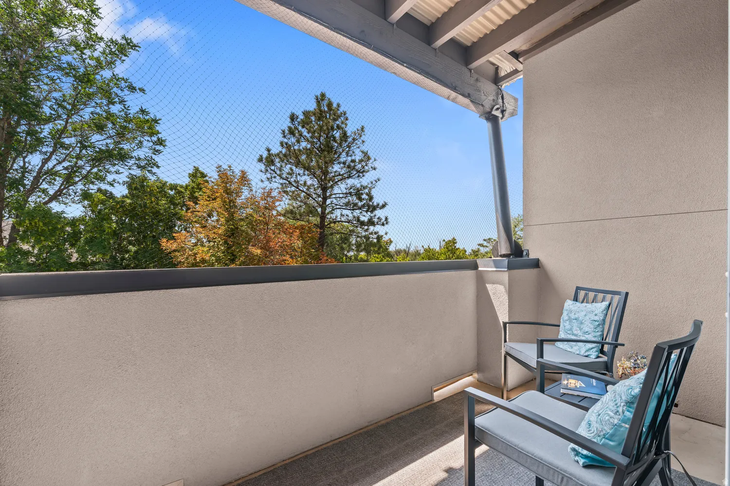Private balcony featuring a textured wall finish and a corrugated metal ceiling