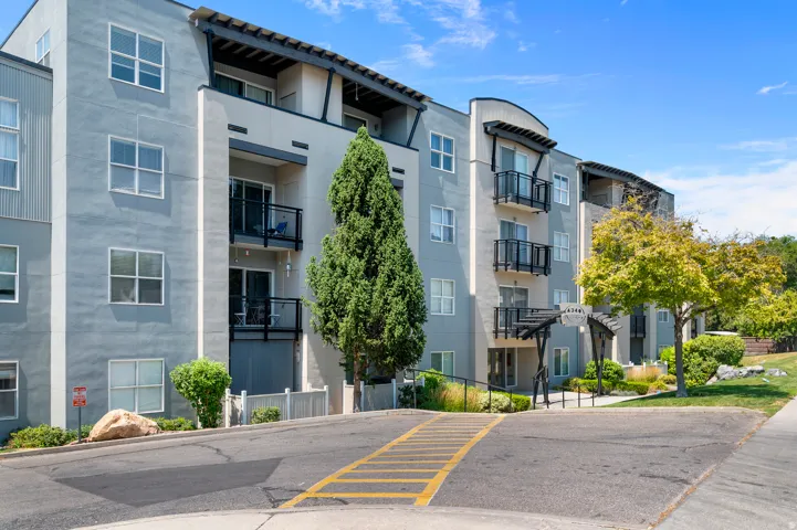 Multi-story building exterior featuring light grey stucco and horizontal siding accents
