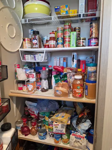 Built-in pantry shelving featuring white wire racks and wood-finish shelving