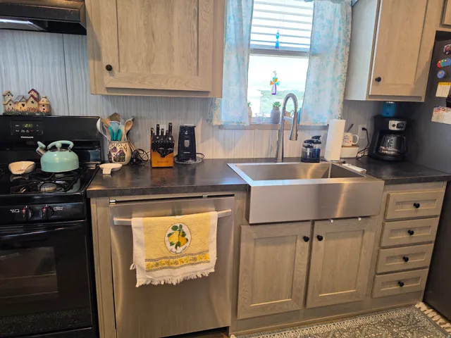 Modern  Kitchen with Stainless Steel Apron Sink and Solid Wood Finish CabinetryThis kitchen features custom wood-finish cabinetry paired with a large stainless steel apron-front sink and professional-style faucet