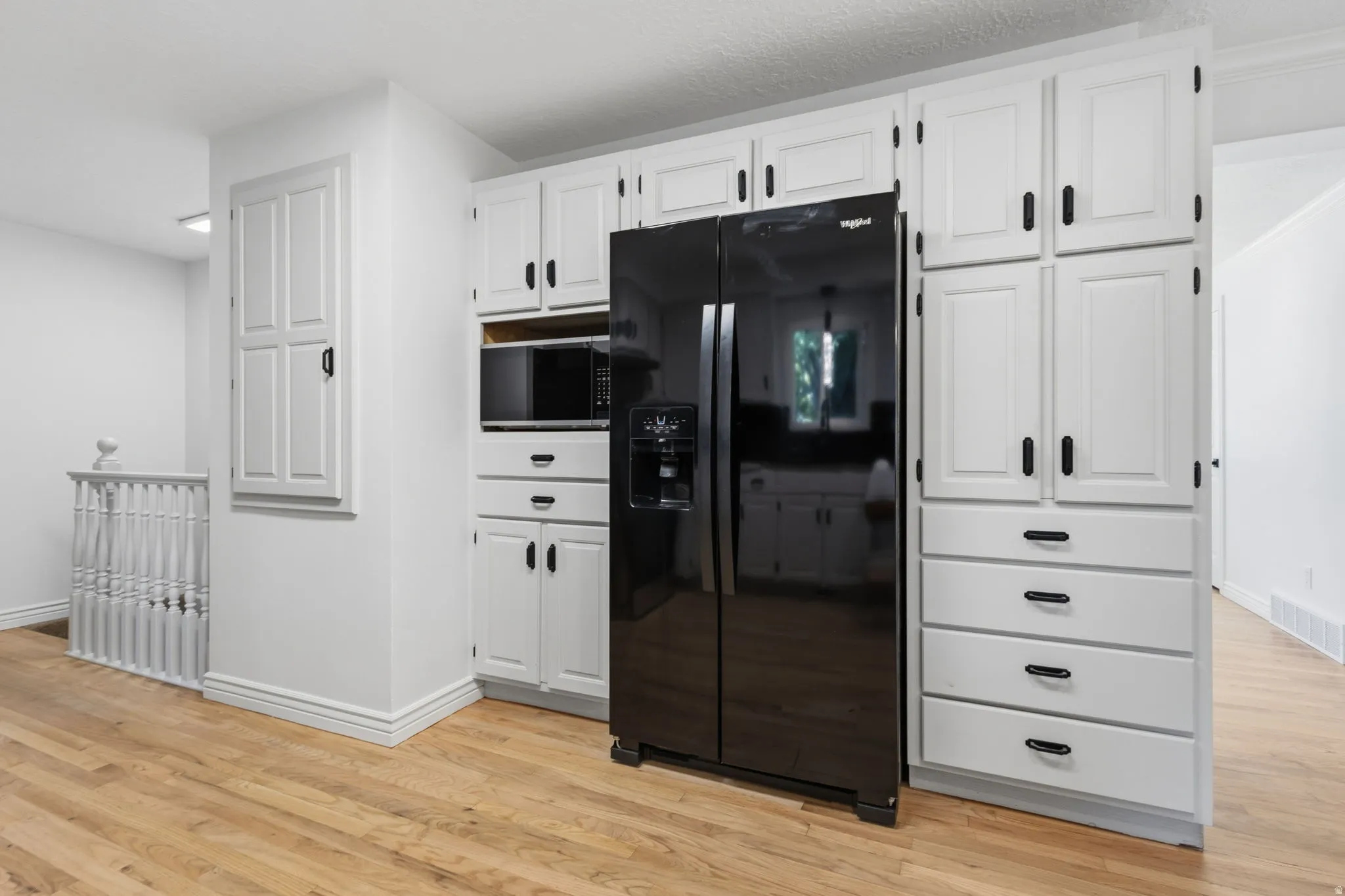 Fully updated kitchen featuring granite countertops and backsplash, refinished cabinets with new hardware, brand new stainless steel appliances, and hardwood flooring