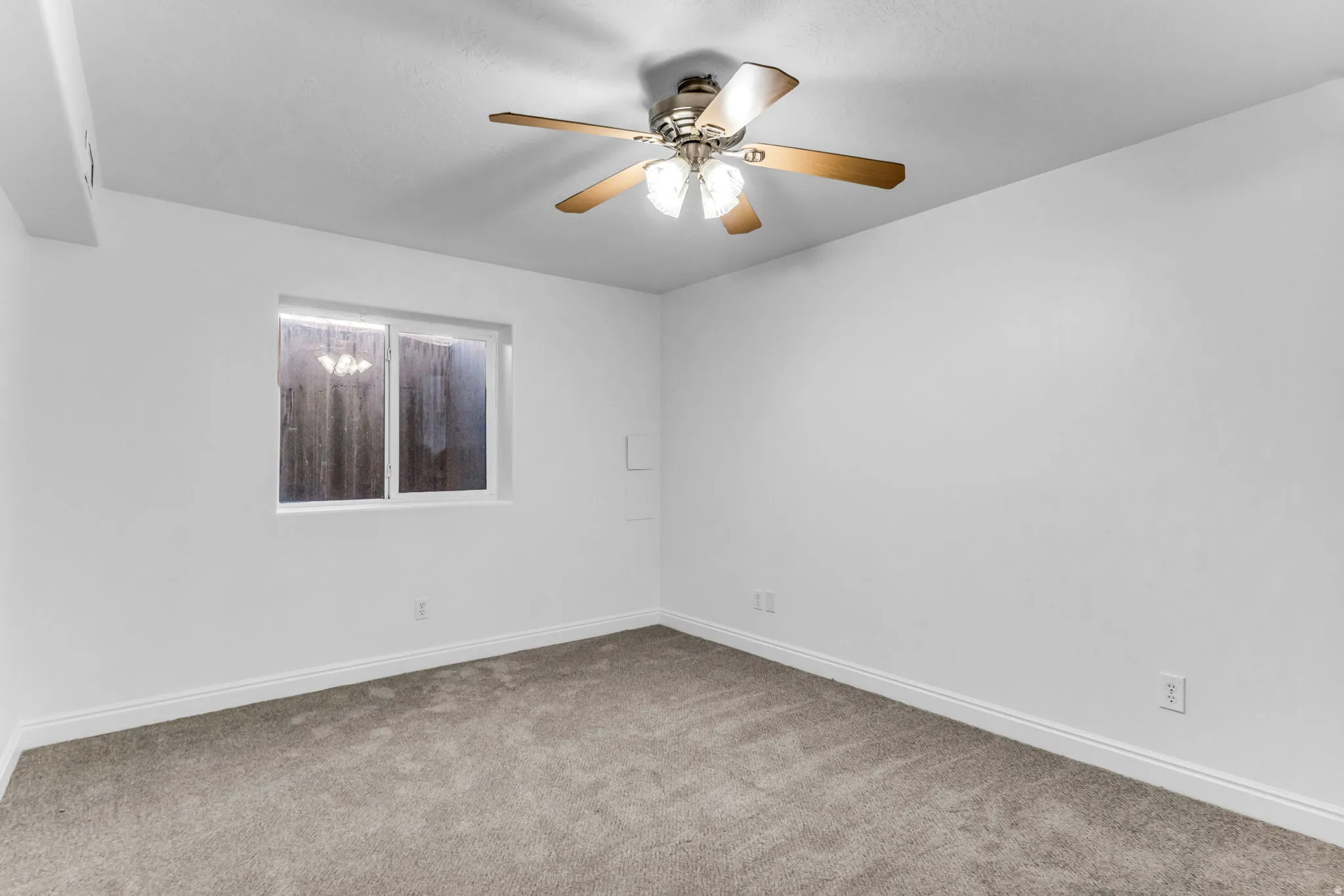 Recessed window with white trim, ceiling fan with light fixture, carpeted flooring, and white painted walls