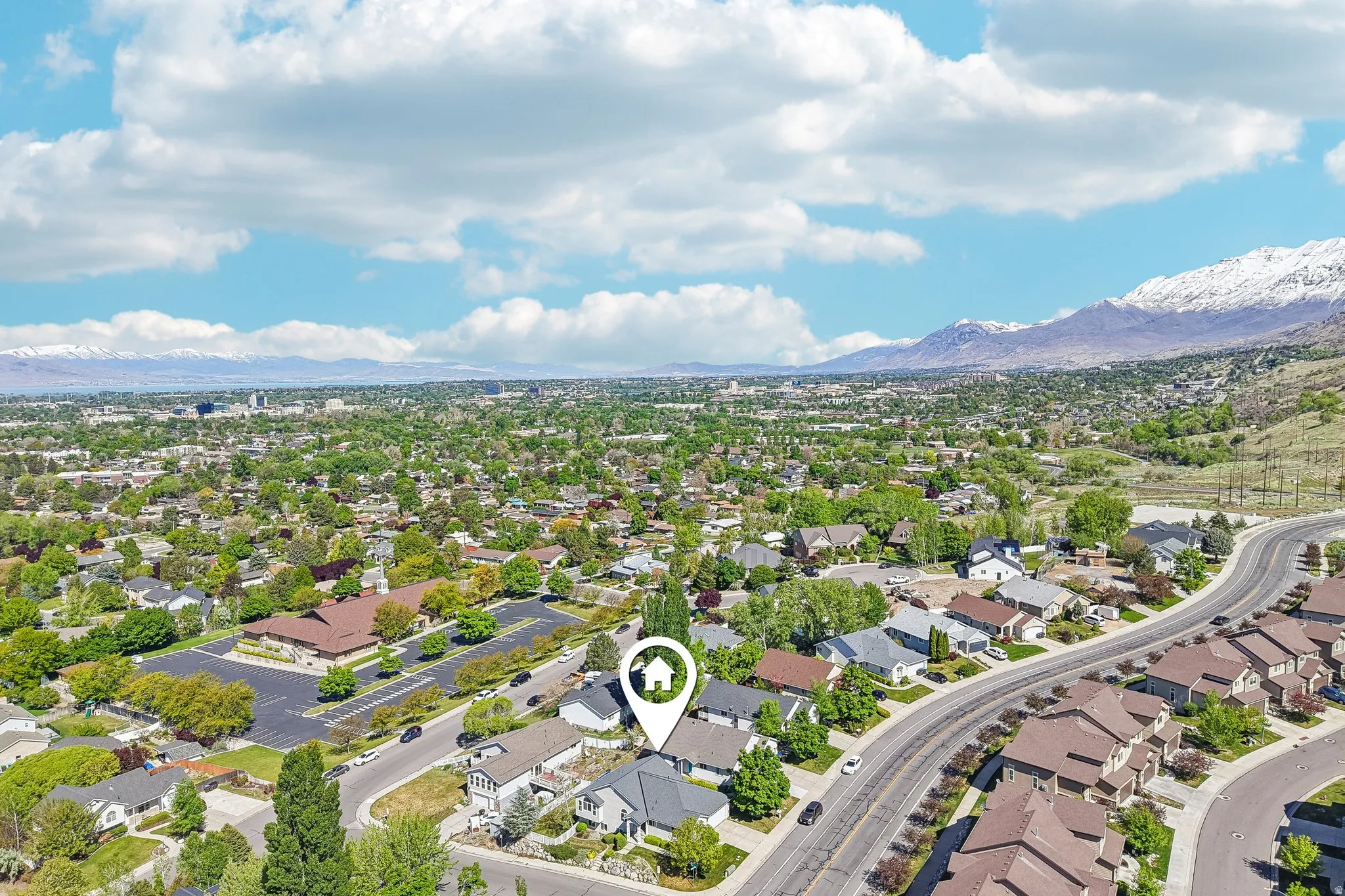 Aerial view of a thriving residential community featuring tree-lined streets, manicured landscaping, and low-density single-family homes with varied architectural styles