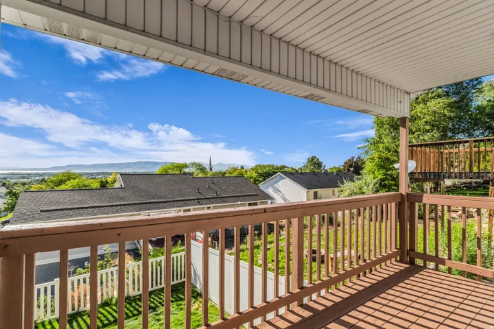 Covered outdoor balcony with wood-finish railing and decking