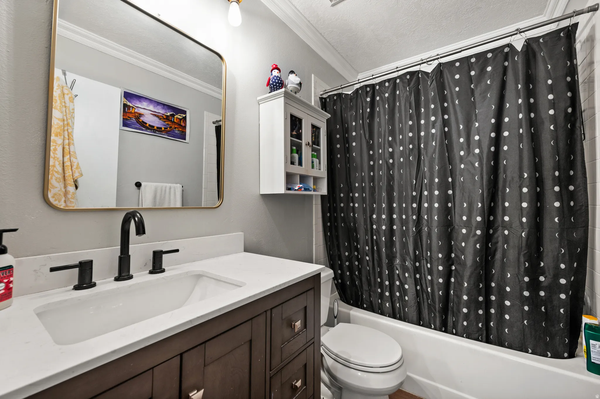 Bathroom vanity featuring a vessel sink, dark wood-finish cabinetry, and matte black fixtures