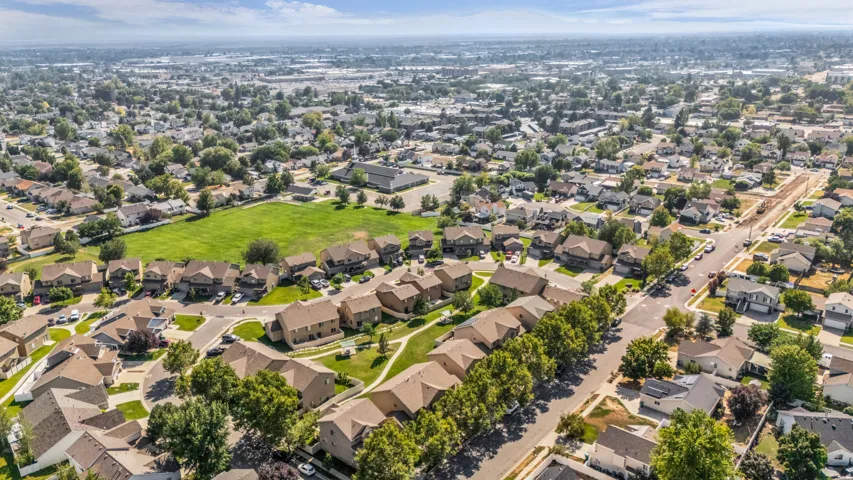 Expansive residential development featuring a variety of single-family homes, mature street trees, a community green space, and curvilinear streets