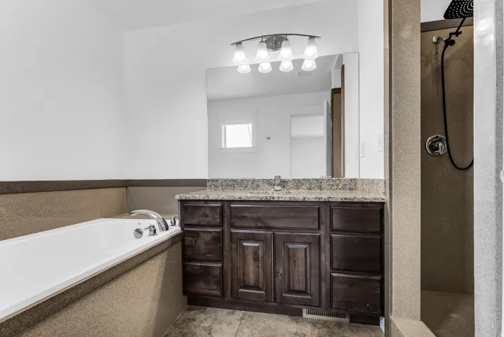 Bathroom with a dark wood-finish vanity, light-toned countertop, and a large mirror
