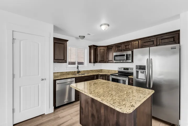 Gourmet kitchen featuring rich wood cabinetry, granite countertops, and a generous island with seating