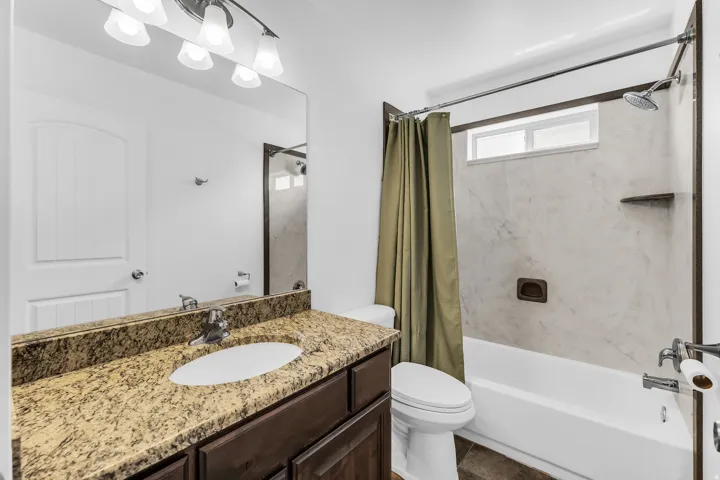 Spa-inspired bathroom featuring a granite-topped vanity with dual sink basin, oil-rubbed bronze hardware, and ample counter space