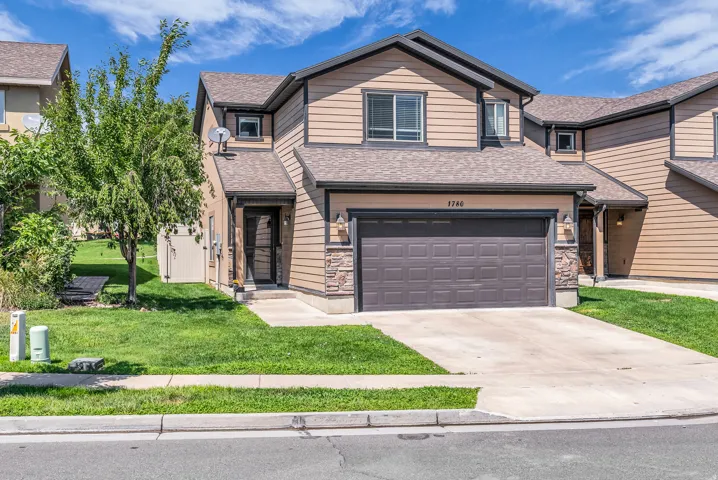 Two-story residence featuring light brown horizontal siding with darker trim accents