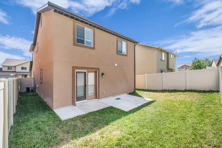 Rear exterior with stucco siding and a concrete patio