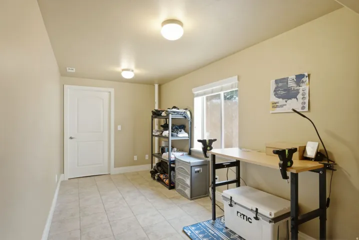 Bright, versatile room with soft yellow walls, tile flooring, and recessed ceiling lighting