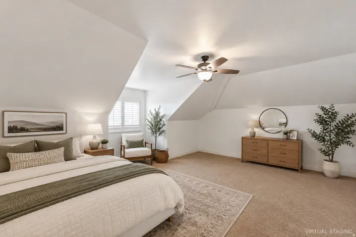 Bright, airy primary bedroom suite featuring vaulted ceilings with ceiling fan, wood-finish flooring, and neutral wall finishes