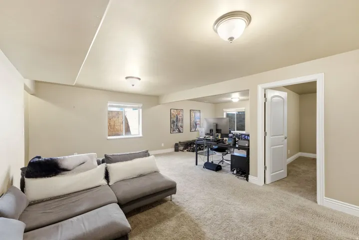 Carpeted open-concept room featuring light beige walls and white trim