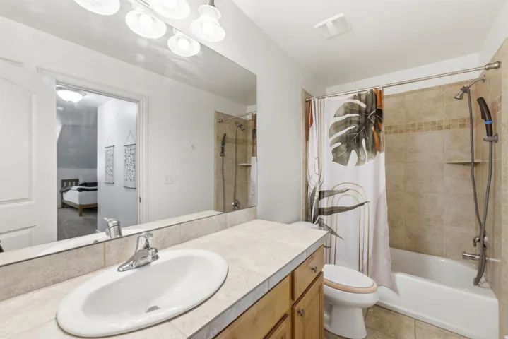 Bathroom featuring a vanity with a white oval sink and chrome faucet, set into a tiled countertop