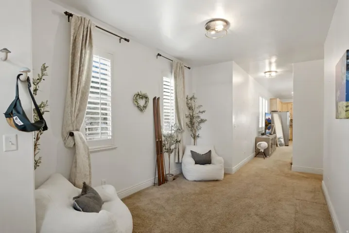 Bright hallway featuring neutral walls, recessed ceiling lighting, and warm wood-finish flooring throughout