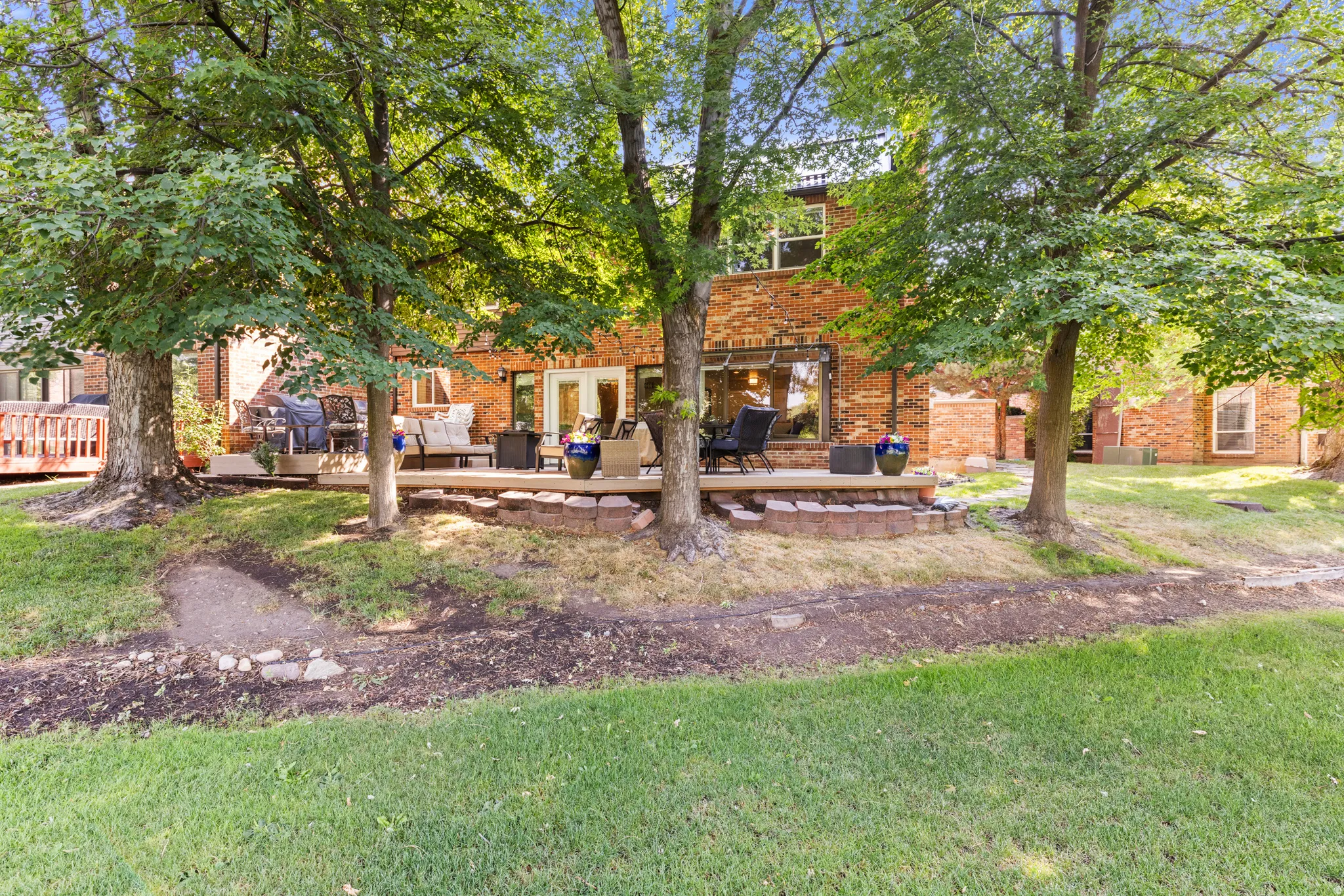 Brick Colonial residence with a sprawling lawn anchored by mature shade trees