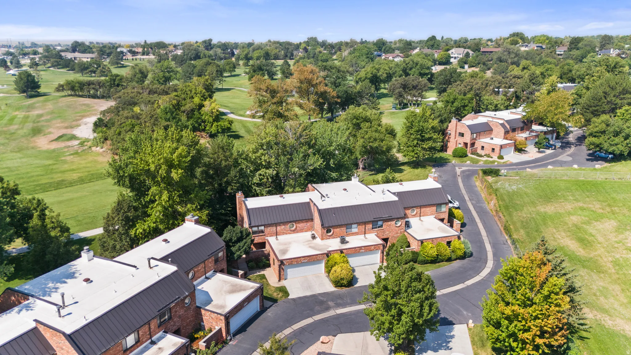 Brick exterior with black metal roofing and attached garages