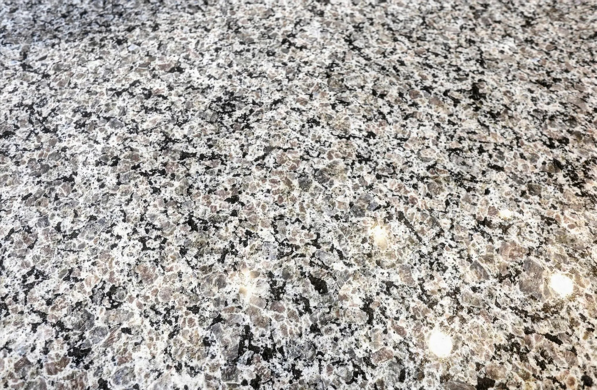Granular stone surface with speckled black and gray tones