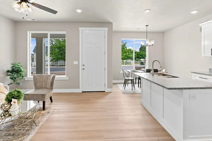 Wood-finish flooring throughout, bright white trim, recessed lighting, and a modern ceiling fan