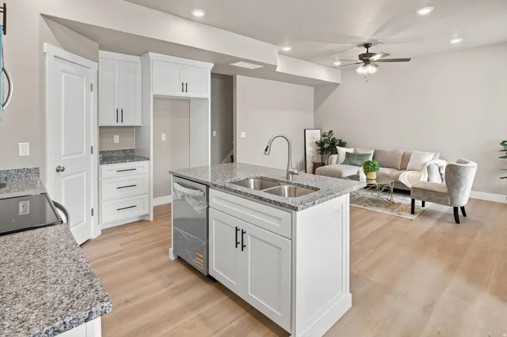 Kitchen with white cabinetry, granite countertops, and wood-finish flooring