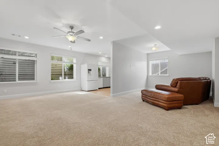 Spacious living area with recessed lighting, ceiling fan, and carpeted flooring