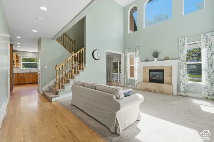 Two-story living area with a fireplace featuring a stone surround, large windows, and an arched transom window