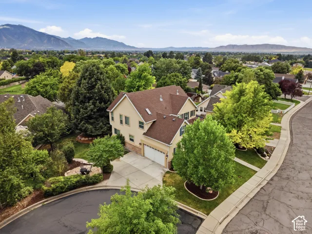 Traditional two-story residence with an attached double garage, featuring a concrete driveway and mature landscaping