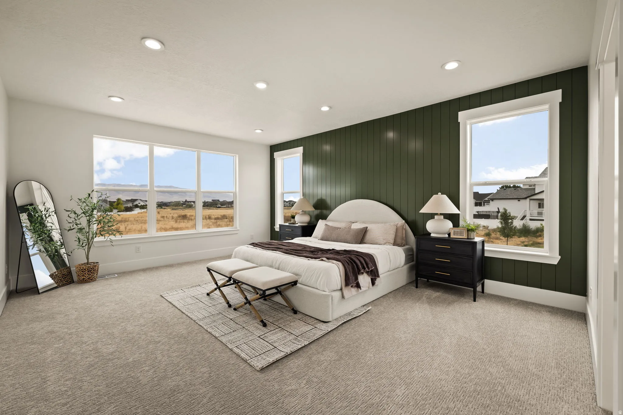 Spacious bedroom with a shiplap accent wall, multiple windows, plush carpet flooring, and recessed lighting