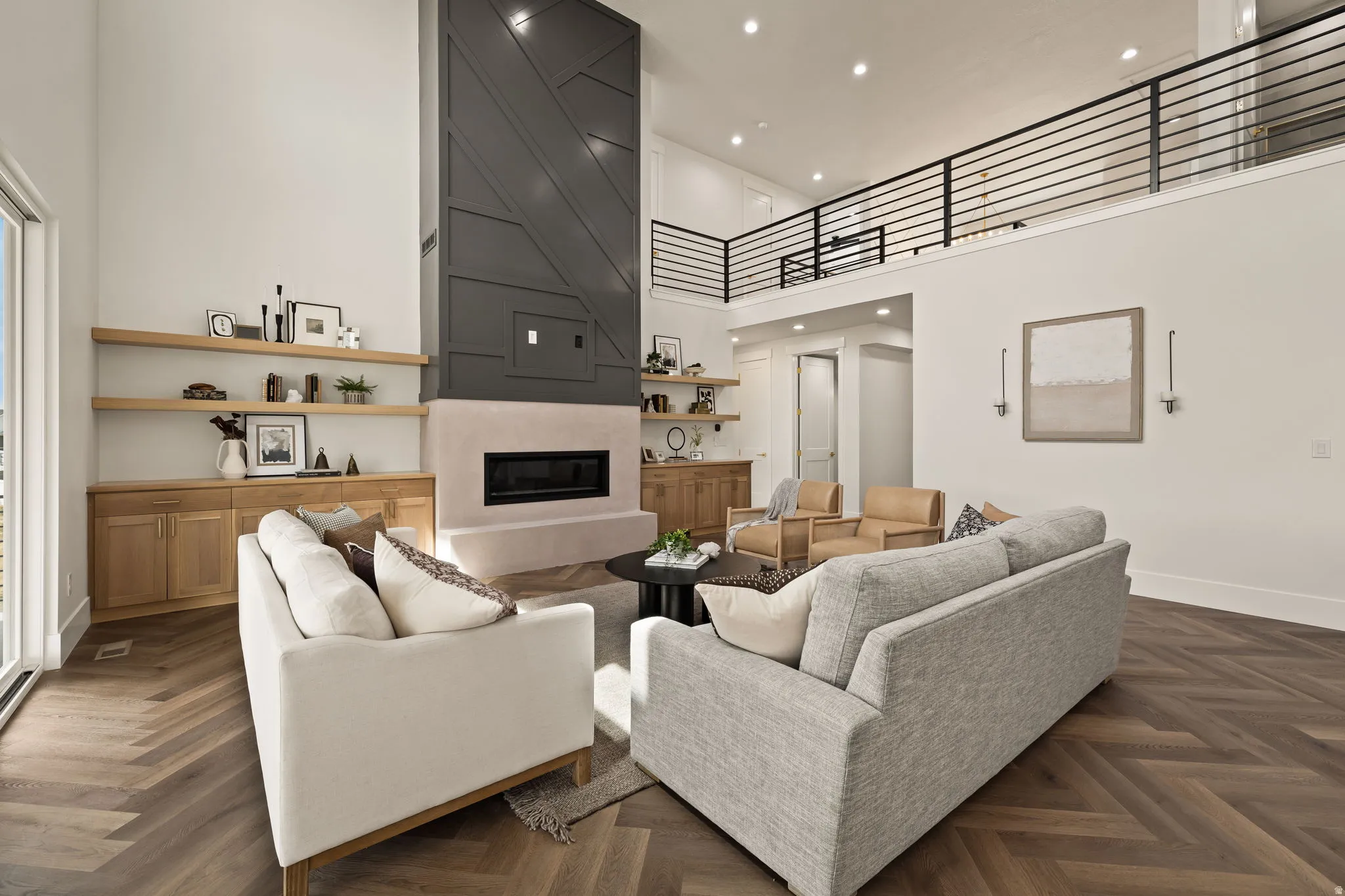 Spacious living area featuring a two-story fireplace with a dark paneled surround and a light-toned hearth