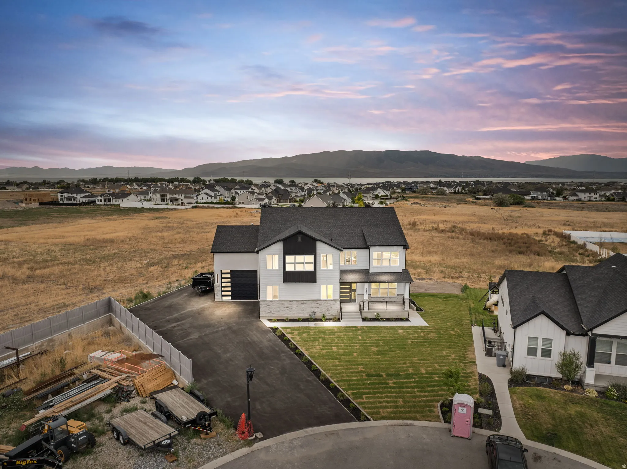 Modern two-story residence featuring a white and dark gray exterior with stone accents